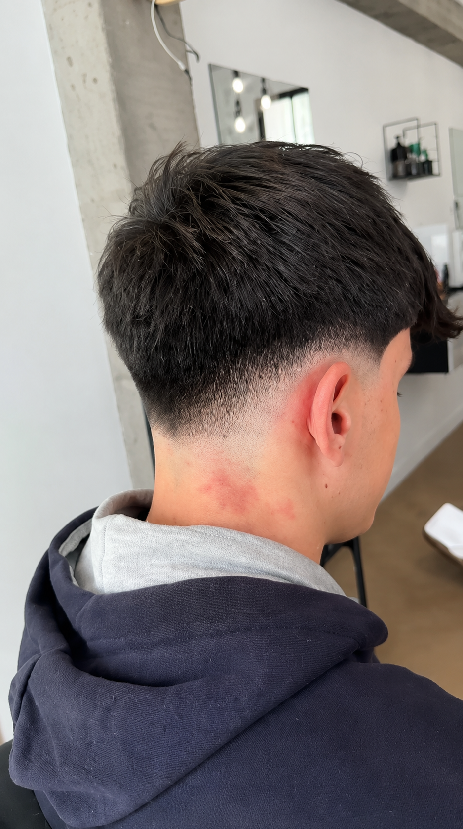 Mid fade con textura en la parte superior y degradado limpio en GRX Barber Club Granada